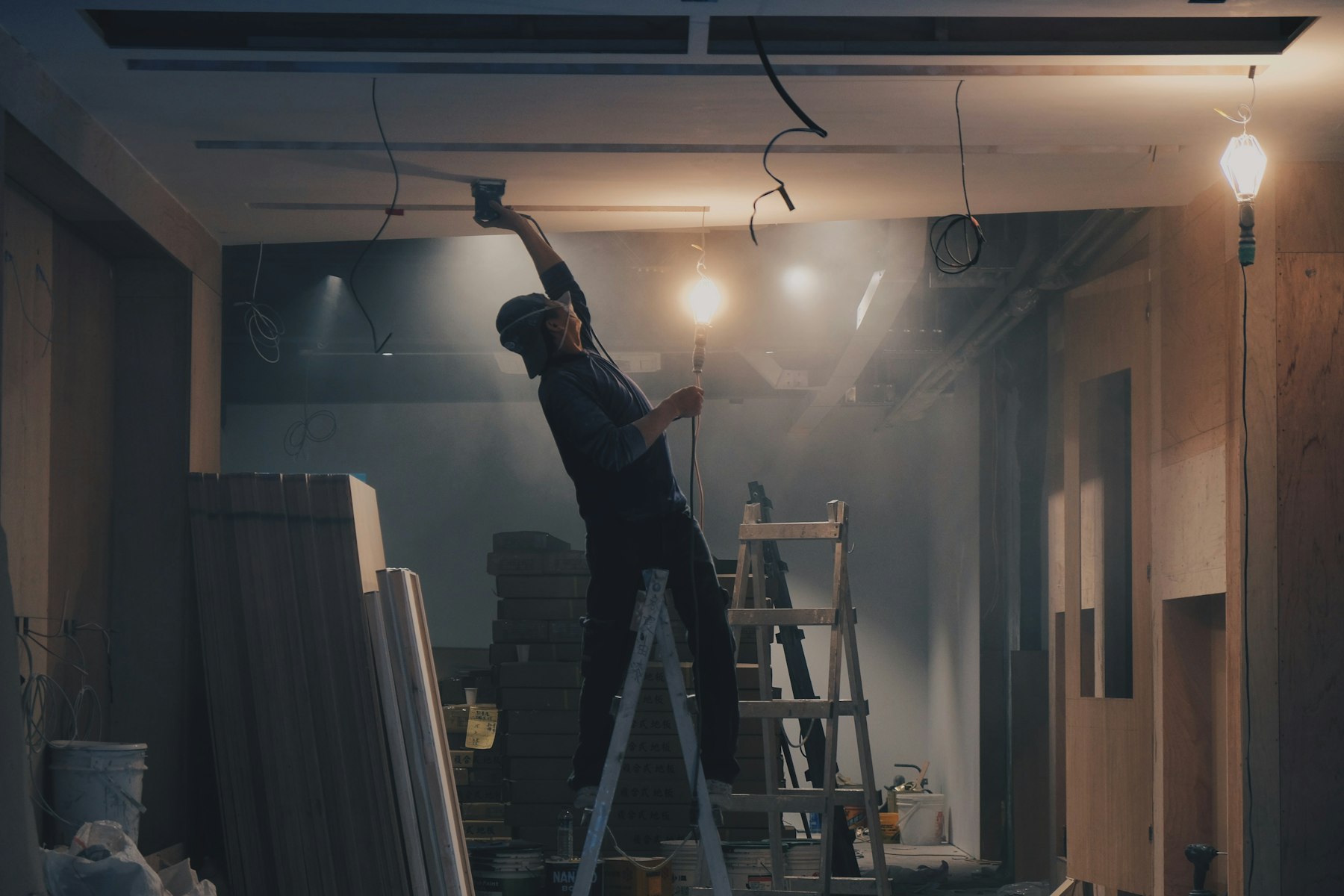 Electrician working in a dim industrial hall